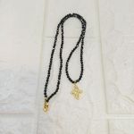 Εξαιρετικό κολιέ από ημιπολύτιμο μαύρο σπινέλιο που γυαλίζει αντανακλώντας το φως και μοτίφ σταυρό 316 L ατσάλινο με πετράδια ζιργκόν.