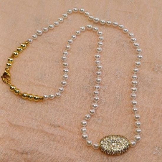 Κολιέ με sell pearl ημιπολύτιμες πέτρες, χρυσούς αιματίτες και μοτίφ επίχρυσο με λευκά ζιργκόν.